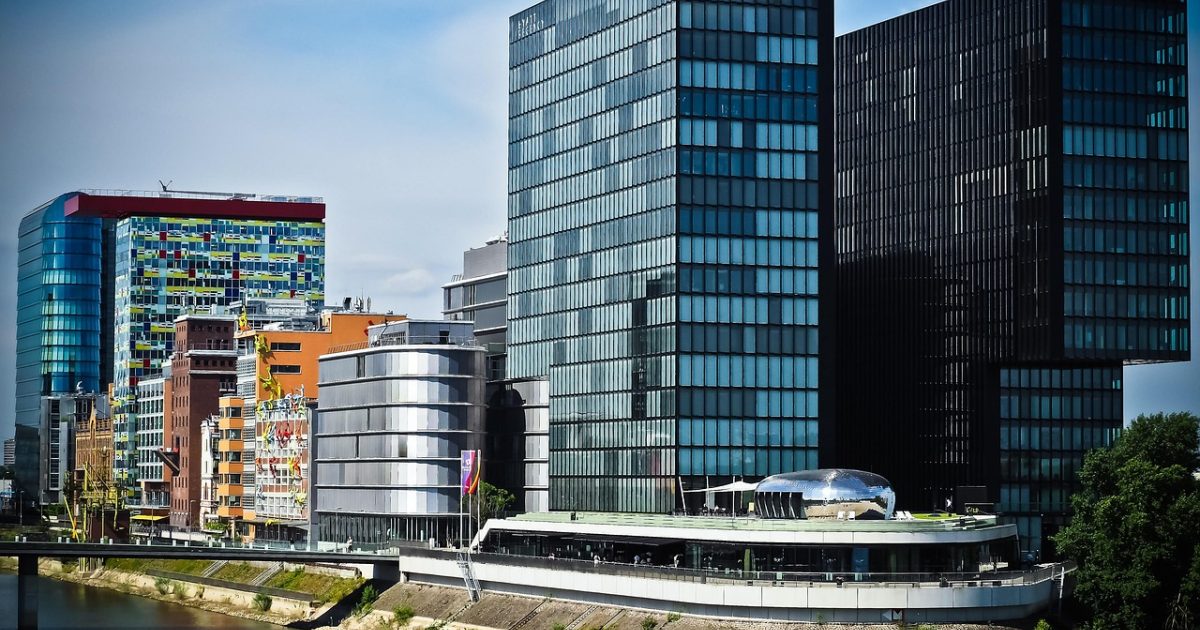 城市核心区的卫星影像，方格状路网与高层建筑阴影交错，屋顶结构与街区边界清晰可见